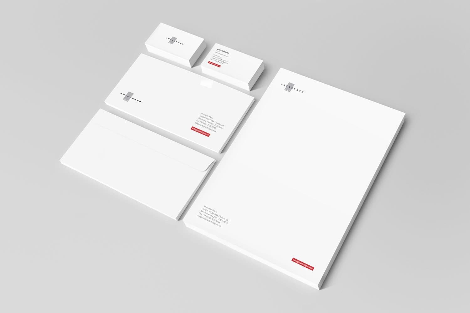 Brand stationery mockup showing white letterhead and business cards on a grey surface