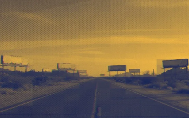 Warm yellow golden landscape with a lone figure standing on a wide road